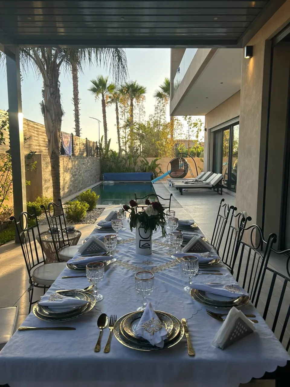Long private dining table prepared beside a Marrakech villa pool